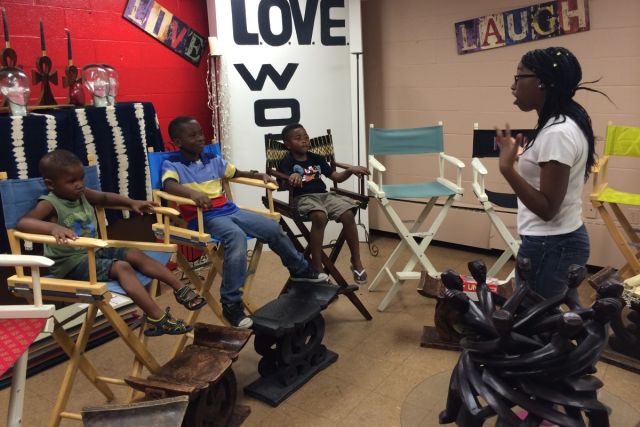 A young African American woman speaks to a few young children about Keep Love Present concepts.